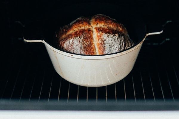 In einem Ofen steht ein in einem Topf gebackenes Brot