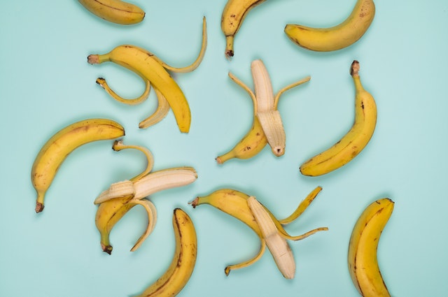 Bananen, geöffnet und geschlossen auf einem hellblauen Hintergrund