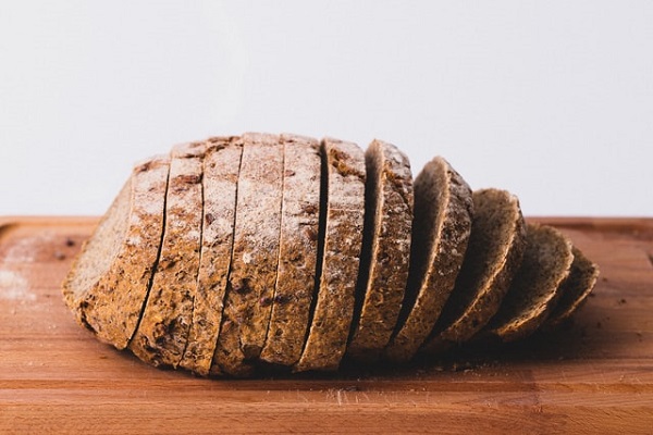 Auf einem Holzbrett liegt ein in Scheiben geschnittenes Brot.