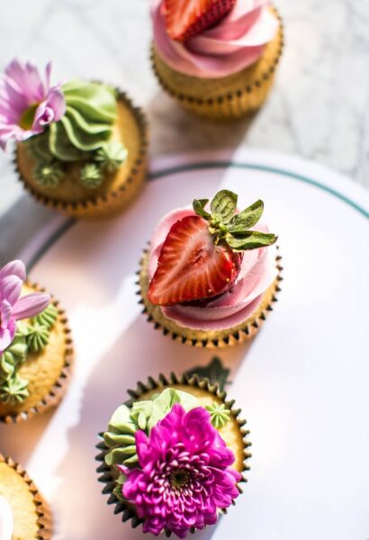 Einige Cupcakes sind mit essbaren Blumen verziert