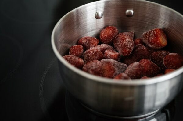In einer kleinen Edelstahlschüssel liegen mehrere gefrorene Erdbeeren