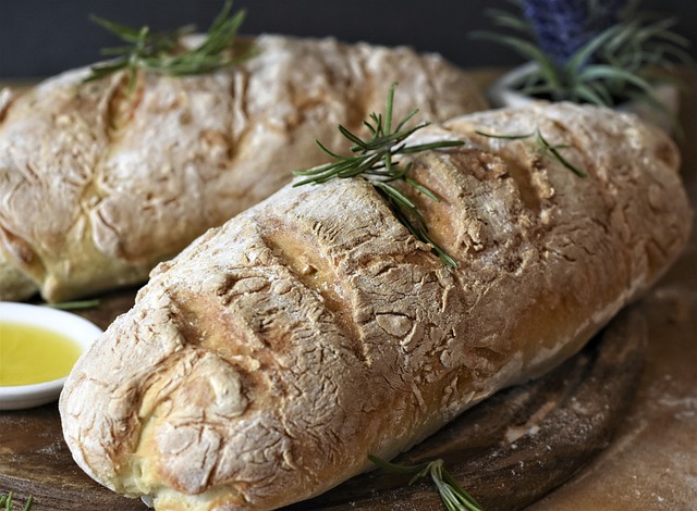 Ein Brot ist dekorativ eingeschnitten und mit Kräutern verziert