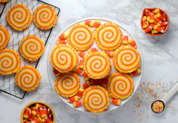 Auf einem Teller und einem Gitter liegen Kekse, mit gelb- und orangefarbenem Muster