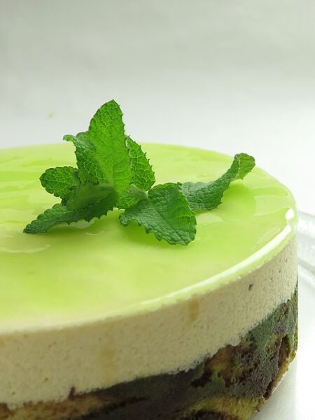 Ein Kuchen ist mit einer grünen Creme bestrichen und mit frischer Minze dekoriert