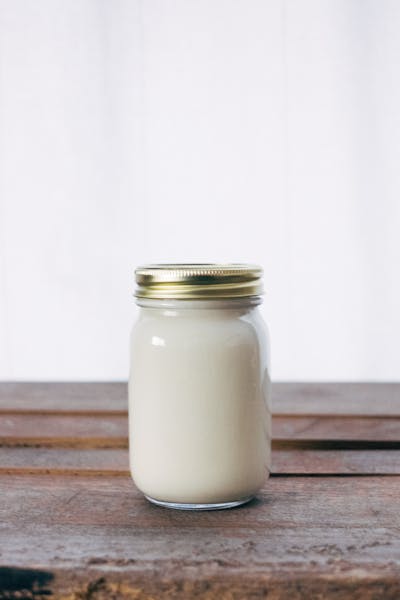 Ein Einmachglas gefüllt mit einer milchig-cremigen Substanz wie Joghurt oder Kefir